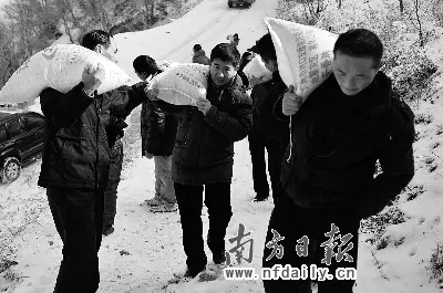 李俊夫(中)在援建威州时,冬天背大米上山慰问村民.徐兴进摄