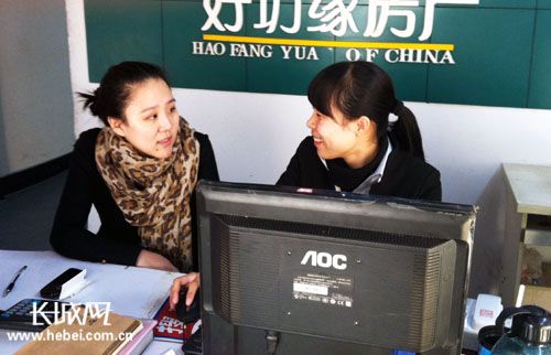记者(左)向张彩凤学习房源录入。