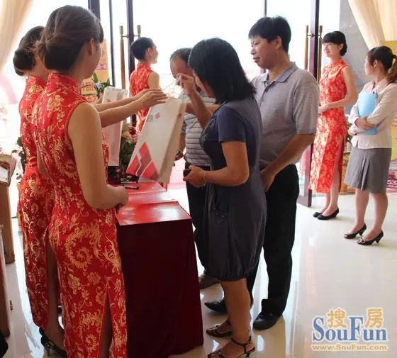 礼仪小姐为到场客户派发礼品