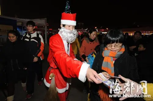 万象城外,一商家员工装扮成圣诞老人派发宣传单