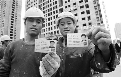去年10月29日，山东青岛市，工人们正在展示刚领到的居住证。