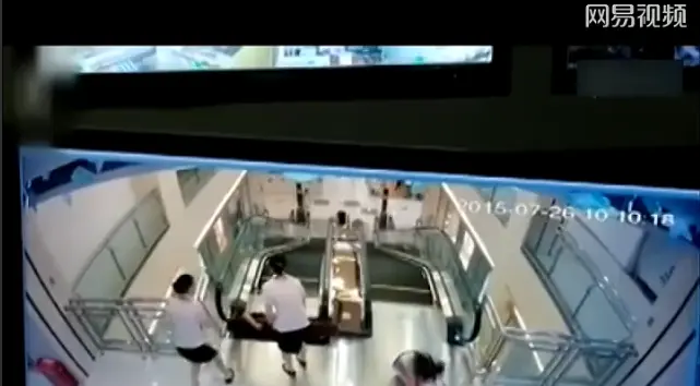 荆州沙市安良百货内,一女子带着儿子搭乘商场内手扶电梯上楼时,遭遇
