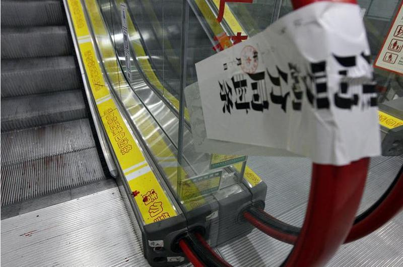 湖北荆州市安良百货公司发生一起手扶电梯事故,一名提举着幼儿的女子