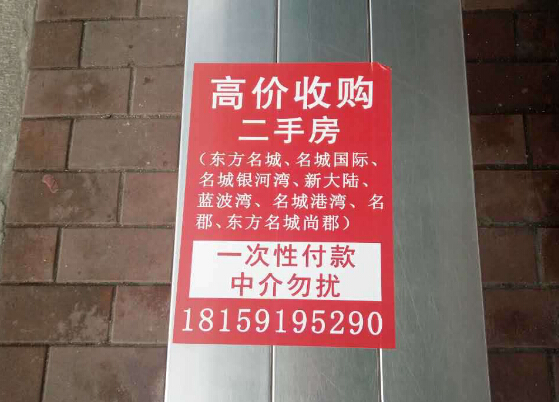 东江滨大大小小的外墙,灯柱上都贴上了"高价收购二手房"的小广告,广告